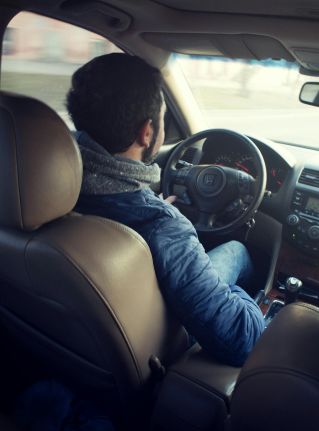 Man Wearing Blue Jacket Sitting Inside Car While Driving